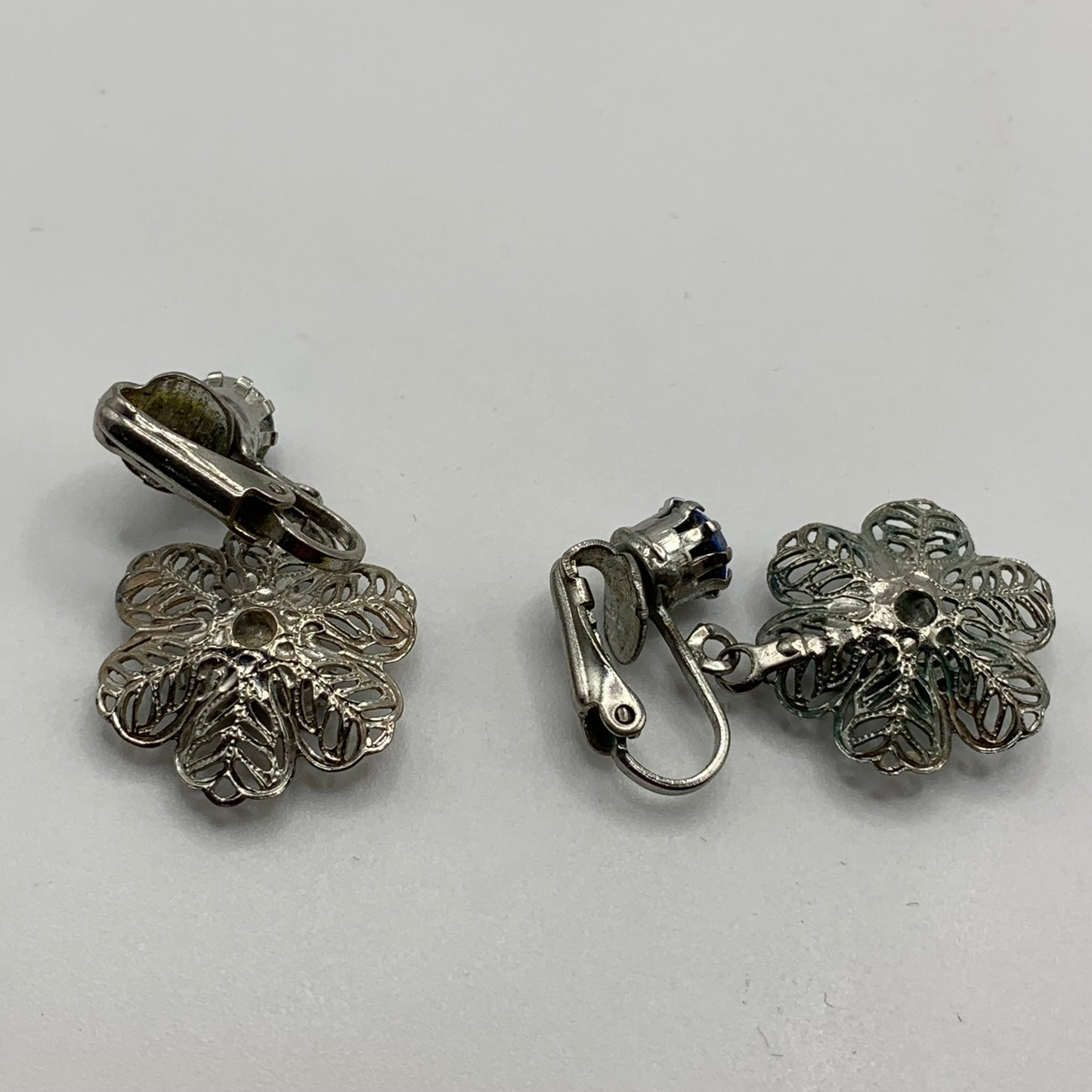 Vintage unsigned silver tone filigree flower blue rhinestone screw back earrings